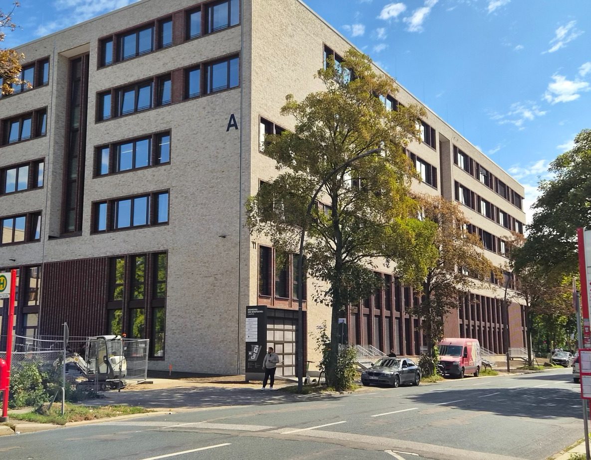 Schild mit Informationen und Wegbeschreibung zum Gebäude, modernes Architekturelement.